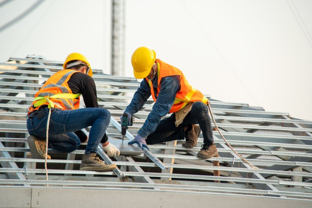 Roofer worker install new roof,Ceramic Roof Tiles Installation by Two Caucasian Roofers,Construction Industry,Roofing tools.